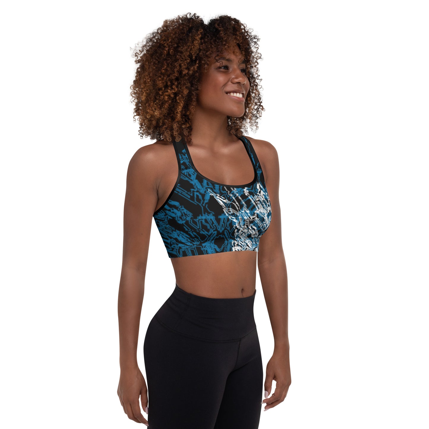 A dark skinned woman smiling wearing the black sports bra with Xenedragon's blue and white geometric wireframe design of the generation three DRGNS.