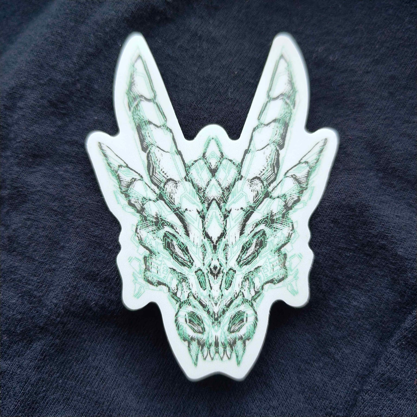 A sticker that features an illustration of a dragon's skull with light green circuit-like design in XeneDragon's art style.