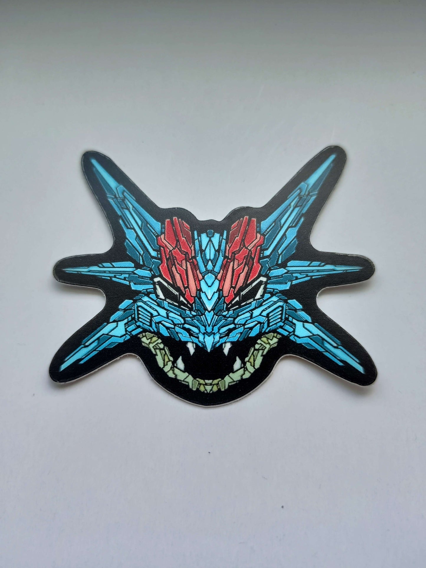 A sticker with a detailed design of a stylized dragon's head. The design features a vibrant blue and red color scheme. Designed by XeneDragon.