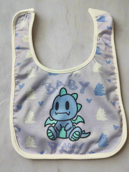 A light purple baby bib with a white border. It features a cartoon blue dragon in the center with the word "BABY" written above it and "DRAGON est. 2024" written below it.