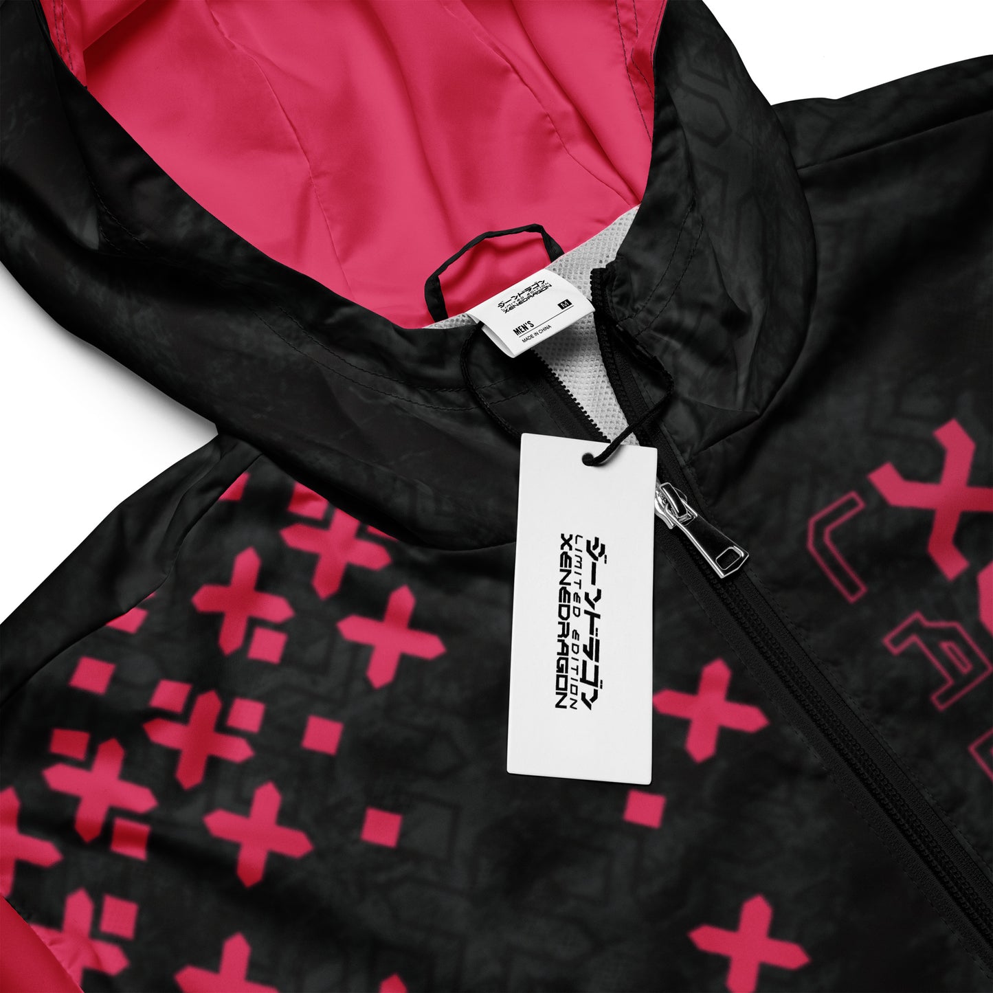 A close-up of A red and black hooded jacket with a zipper. The jacket has a zipper and a tag attached.