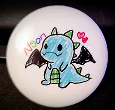 A small button of hand-drawn illustration of a blue dragon with black wings. The word "Neon" is written above the dragon.