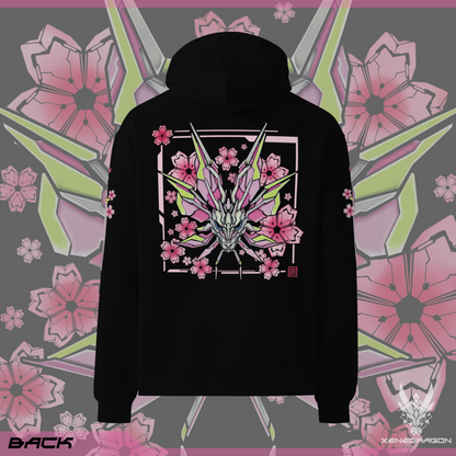 The back of the black hoodie shows a design of a stylized monster's head. The design features vibrant colors like pink, yellow, and blue. There are geometric japanese cherry blossoms within the background. Designed by XeneDragon