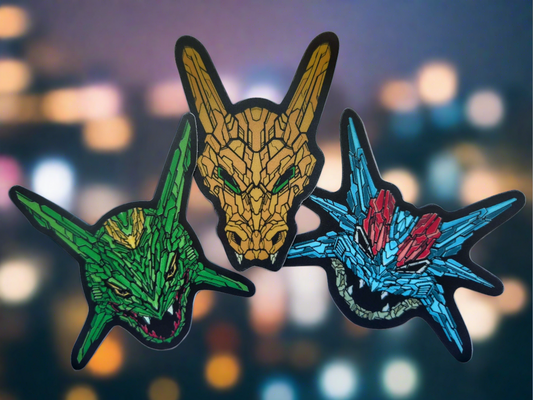 Three vibrant stickers featuring detailed designs of stylized dragon heads in different colors: green, orange, and blue made by XeneDragon.